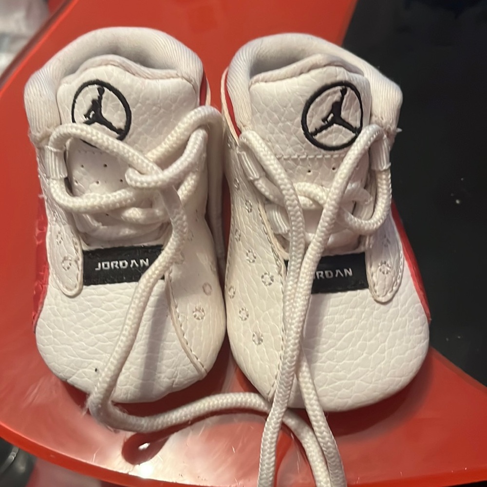 Red and white baby shoes Left side red color is peeling as shown in the pictures